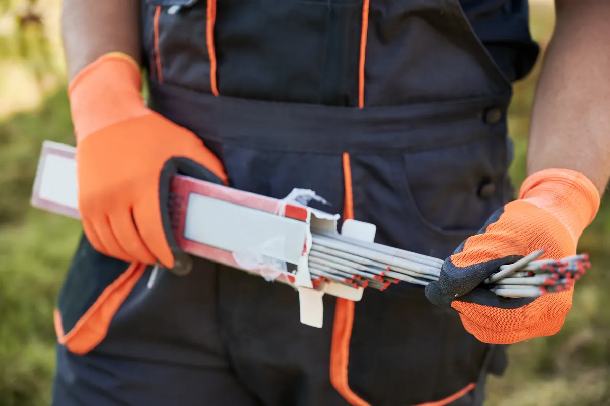 Eletrodos de solda sendo manuseados com luva de protecao